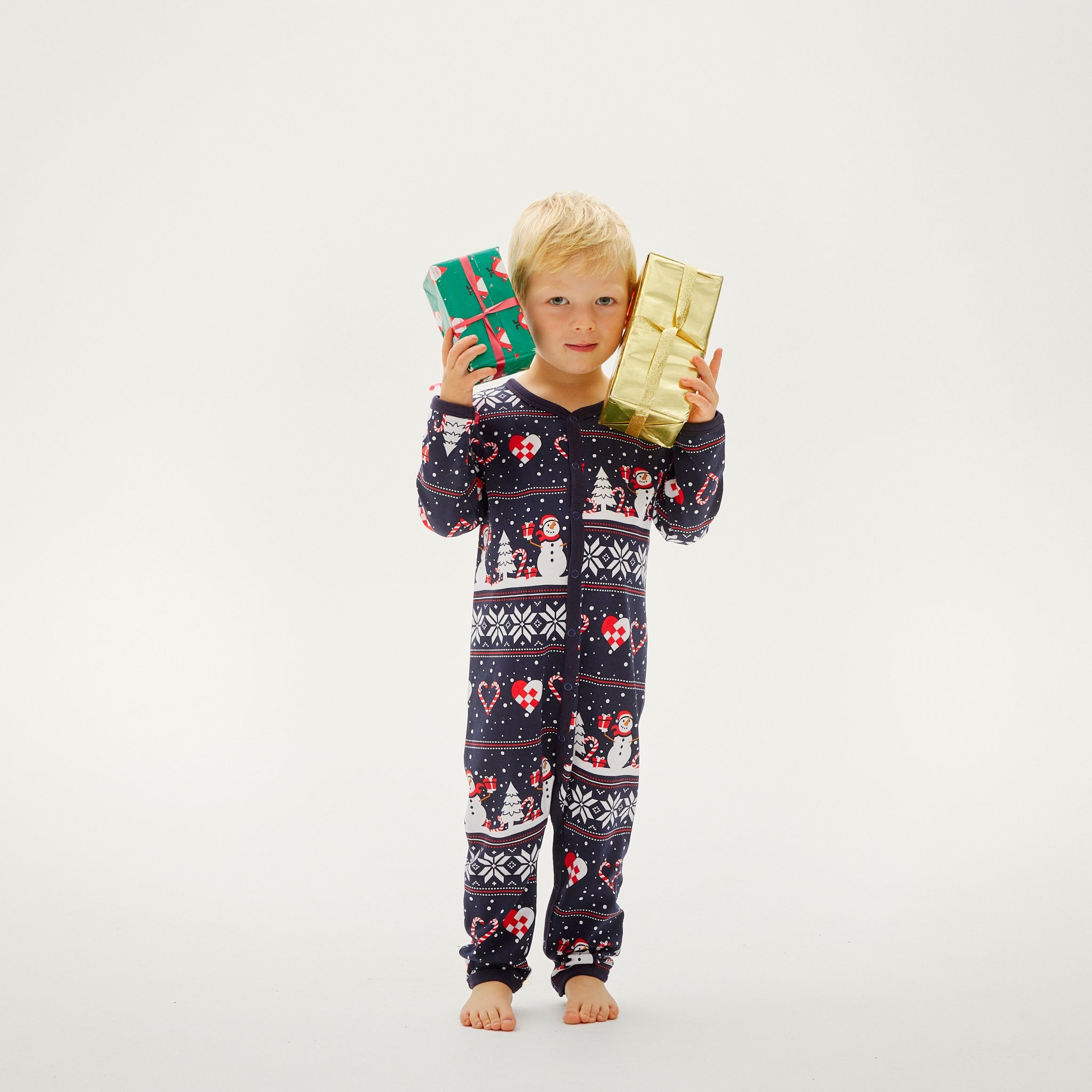 Baby trägt weihnachtspyjama mit blauem Grund und rot-weißem Weihnachtsmuster.